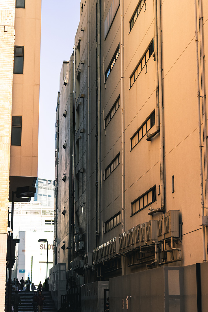 Wide alleyway with pale orange light reflecting on its white walls.